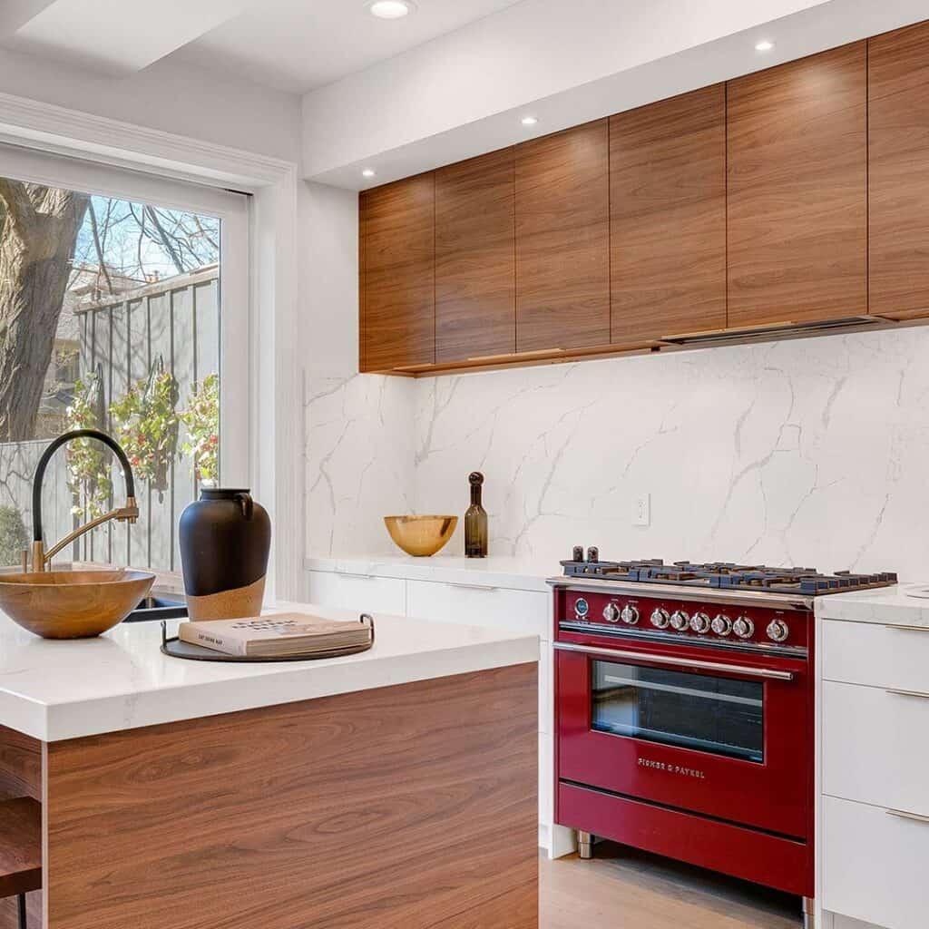 Kitchen space with smooth, wooden cabinets, a red stovetop oven and french doors.