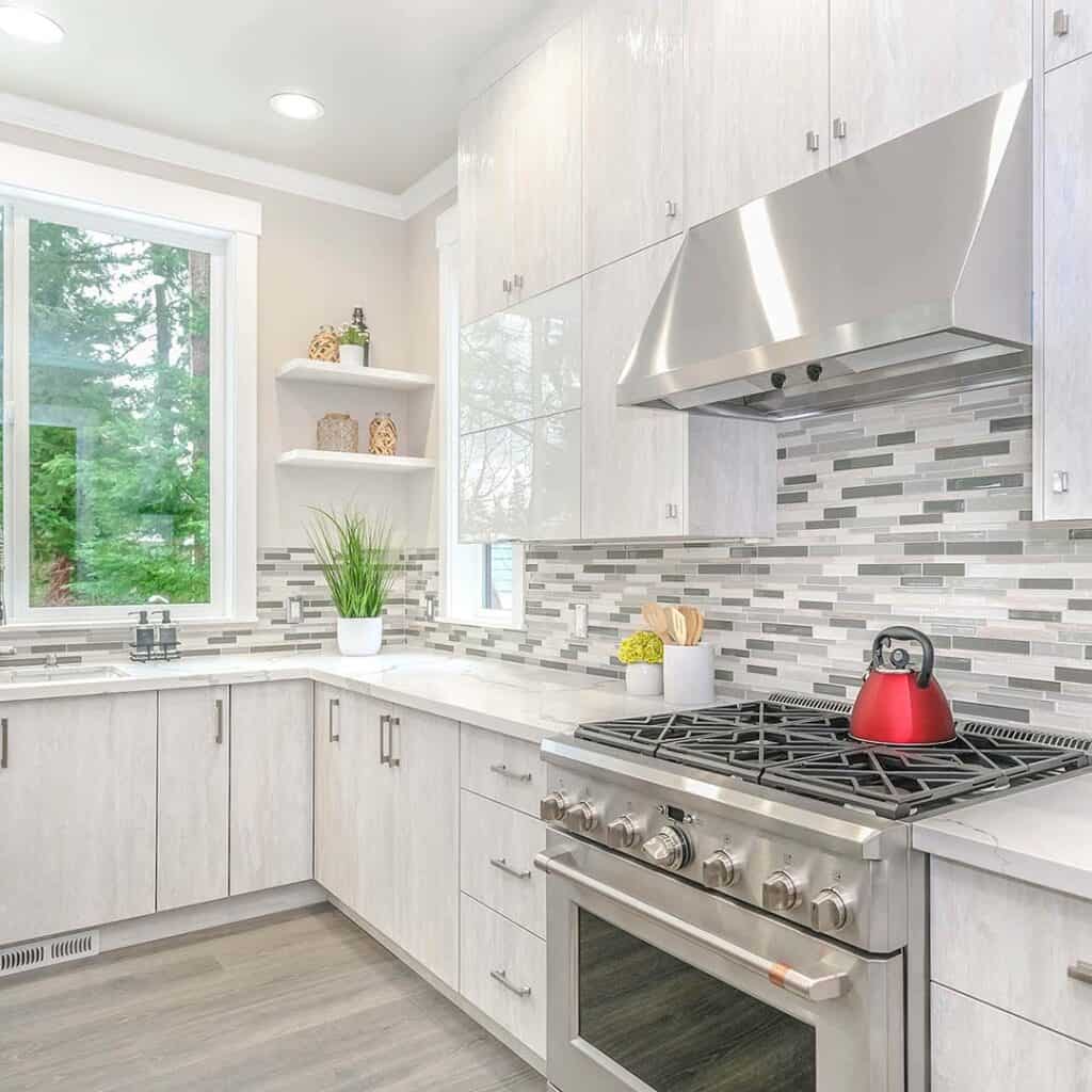  A nice, large kitchen space with white granite countertops and cabinets.