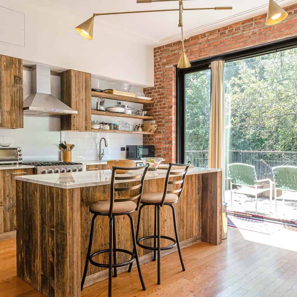 A remodeled kitchen and island with brick finishes and dark brown cabinets.